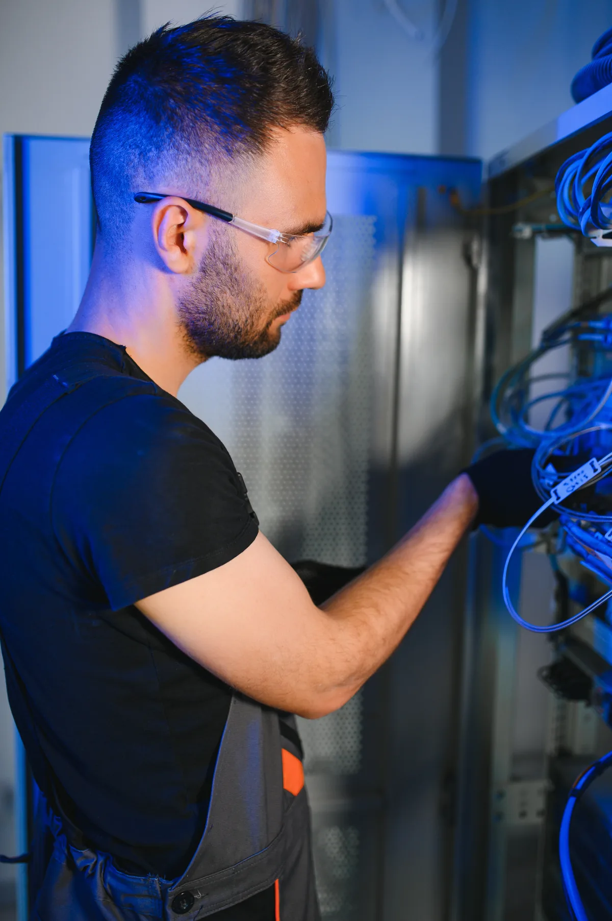Tecnico al lavoro sui collegamenti di un armadio di rete